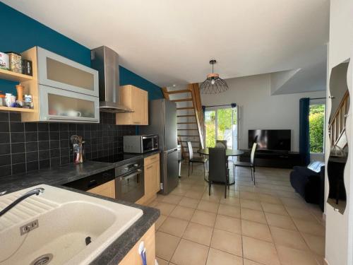 une cuisine avec un escalier et une salle à manger dans l'établissement La Maison du Bonheur 2 ch 65m2 - patio et jardin - Les Mathes - Locsweethome, aux Mathes