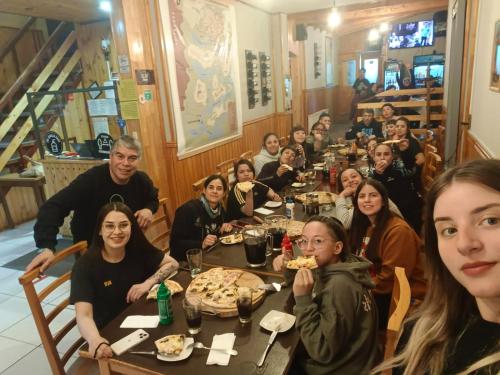 a group of people sitting at a table in a restaurant at Hostal Alcázar in Puerto Natales