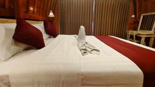 a hotel room with a large bed with towels on it at Green Pacing Lodge in Bangli