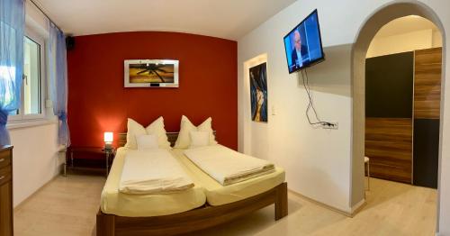 a bedroom with a bed with a red wall at Appartement Christine in Sankt Johann im Pongau