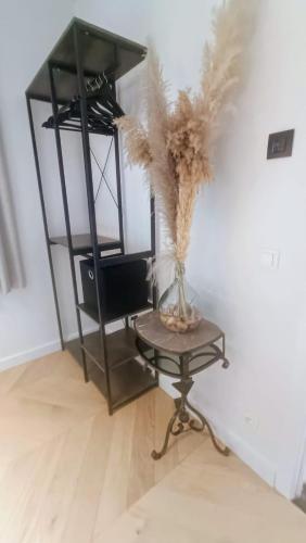 a table with a vase with feathers in a room at B&B Casa Roman & Vakantiewoning voor 1 pers tot max 32 personen in Zonhoven