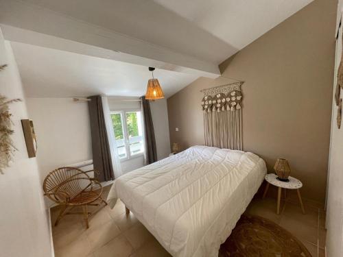 une chambre avec un lit, une chaise et une fenêtre dans l'établissement La Maison du Bonheur 2 ch 65m2 - patio et jardin - Les Mathes - Locsweethome, aux Mathes