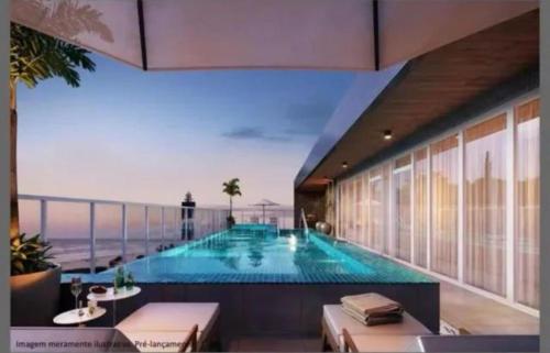 a swimming pool with a view of the ocean at Apartamento Vista Mar atalaia varanda gourmet in Aracaju