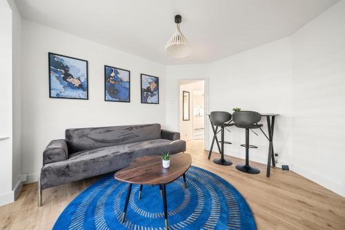 a living room with a couch and a table at 2 Bed Luxury Parking and Garden - Close to Heathrow in London