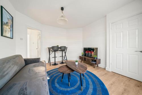 a living room with a couch and a table at 2 Bed Luxury Parking and Garden - Close to Heathrow in London