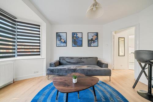 a living room with a couch and a table at 2 Bed Luxury Parking and Garden - Close to Heathrow in London