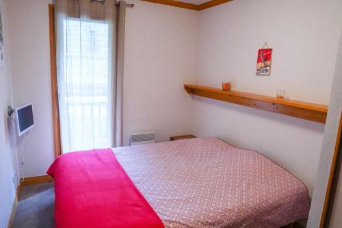 1 dormitorio con cama rosa y ventana en Chalet de la Grand Vy : Appart 6/7 personnes., en Valloire