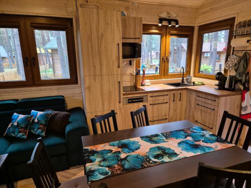 a kitchen and dining room with a table and chairs at Dzik w zagrodzie in Borsk