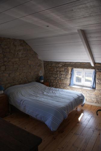 une chambre avec un lit dans un mur de pierre dans l'établissement Maison Le Quéric La trinité sur mer, à La Trinité-sur-Mer