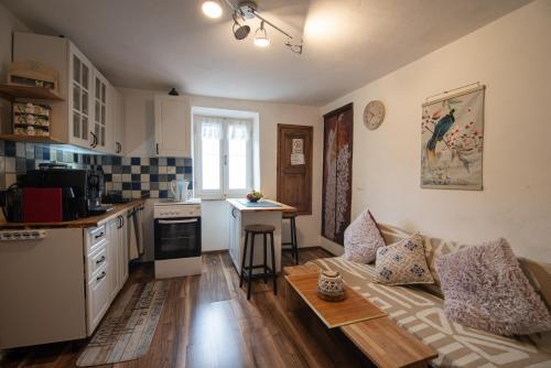 a living room with a couch and a kitchen at Andrea‘s Nido in Castel del Piano