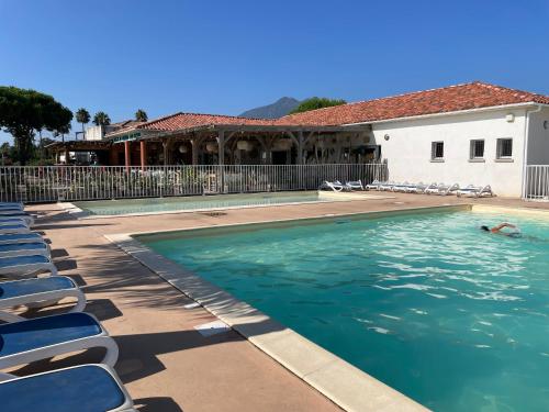 une piscine avec des chaises et une maison dans l'établissement Corsica Poggio, à Poggio-Mezzana