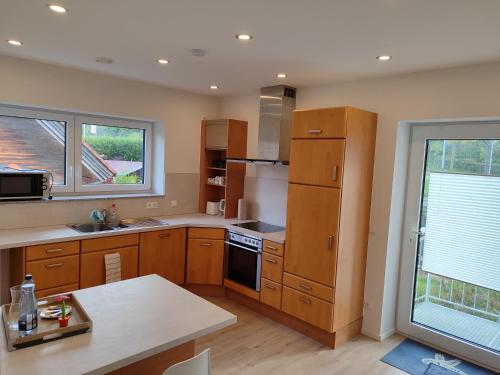 una cocina con armarios de madera y una gran ventana en Apartment Rina, en Villingen-Schwenningen
