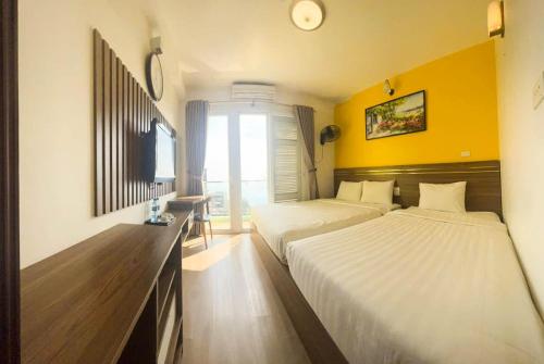 two beds in a room with yellow walls at Khách sạn Hanvet Tam Đảo in Tam Ðảo