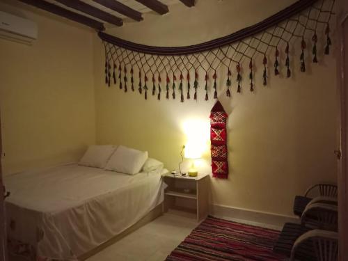 a bedroom with a bed and a table with a lamp at Tunis Camp in Tunis