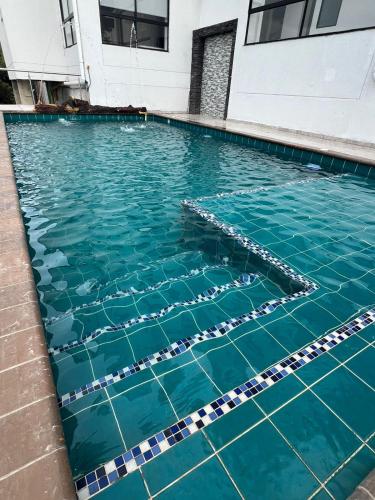 a swimming pool with blue water in a building at Hotel Golden Hills Manizales in Manizales