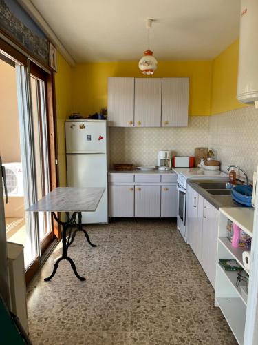 une cuisine avec une table et un réfrigérateur blanc dans l'établissement Appartement studio Fabregas vue mer, à La Seyne-sur-Mer