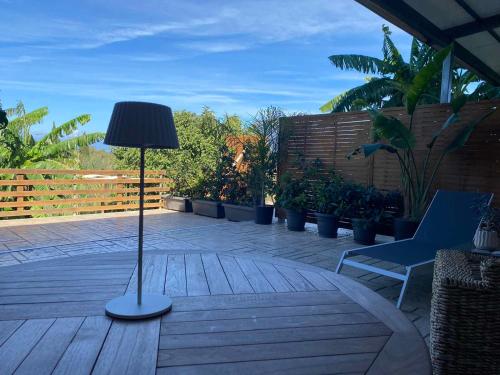 a lamp on a deck with a chair and plants at True Home in Sfakerá