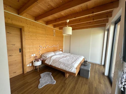 Un dormitorio con una cama y una pared de madera. en Dům splněných přání, en Přáslavice
