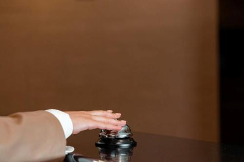 a hand holding a bottle on top of a table at Sky Hotel in Prizren