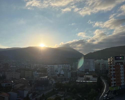 a view of a city with the sun in the sky at Sky Hotel in Prizren