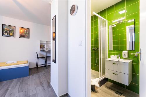 a bathroom with green tiles and a sink at Sobe za odmor Ema in Bilje