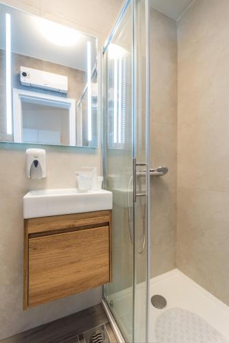 a bathroom with a shower and a sink and a mirror at Sobe za odmor Ema in Bilje