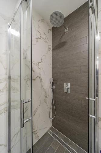 a bathroom with a shower with a glass door at Hemingway Belgrade Apartment in Zemun