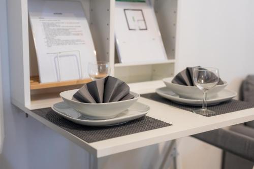 a table with two bowls and wine glasses on it at Sobe za odmor Ema in Bilje