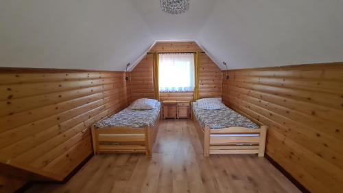 a room with two beds in a cabin with a window at Dom Derbend na wyłączność in Sztutowo