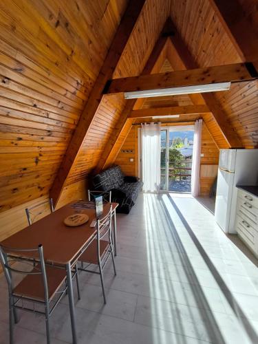 Cette chambre mansardée comprend une table et des chaises. dans l'établissement Petit chalet avec terrasse, à Oust