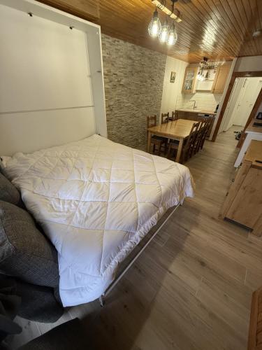 - une chambre avec un grand lit dans une pièce avec une table dans l'établissement Appartement Tignes 2100 - 6-8 personnes - 2 chambres - 3 Télévisions - Netflix & Wifi inclus, à Tignes