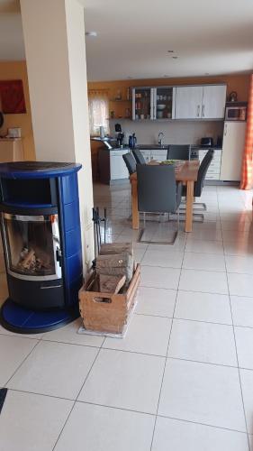 a living room with a fireplace and a kitchen at Ferienhaus direkt am See in Blankensee