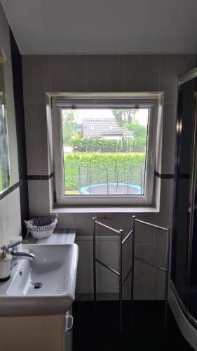 a bathroom with a sink and a window at Dom Derbend na wyłączność in Sztutowo