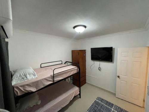 a bedroom with a bunk bed and a flat screen tv at Alojamiento en La Ceiba in La Ceiba
