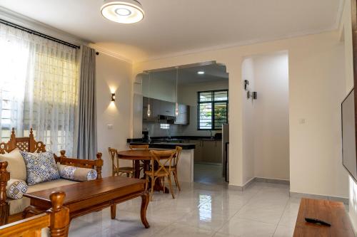 a kitchen and living room with a table and a couch at Leshan Luxury Villas in Diani Beach