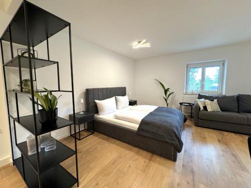 a bedroom with a bed and a couch at ma suite - idyllisch & modern apartment 2-4 P in Ruderatshofen