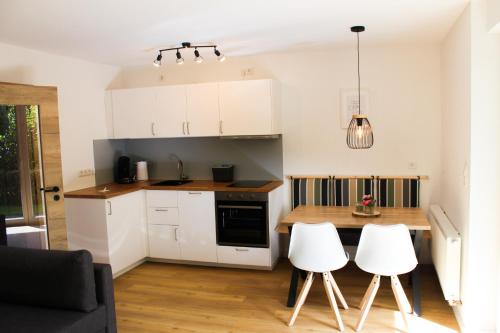 a kitchen with white cabinets and a table and chairs at Ferienwohnung Repetal in Attendorn