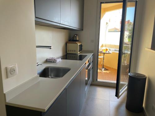 une petite cuisine avec un évier et un micro-ondes dans l'établissement Le refuge d Amaya -Btz, à Biarritz