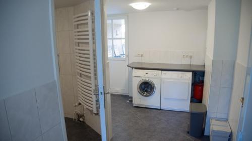 a kitchen with a washing machine and a window at Vakantiehuis Oostendorp in Meddoo