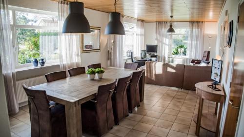 a dining room with a wooden table and chairs at Vakantiehuis Oostendorp in Meddoo