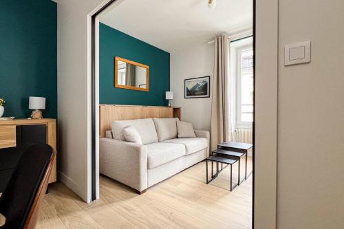 - un salon avec un canapé blanc et un miroir dans l'établissement Spacious T2 in the heart of Chamonix, à Chamonix-Mont-Blanc