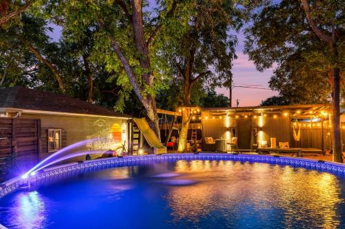 a swimming pool with a slide and a water fountain at The Martin Frisco Stay & Play Hot tub, Pool & Firepit in Frisco