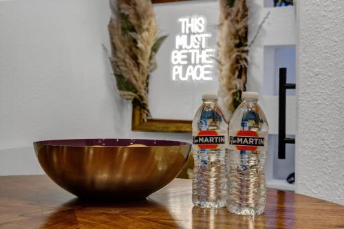 two bottles of water and a bowl on a table at The Martin Frisco Stay & Play Hot tub, Pool & Firepit in Frisco