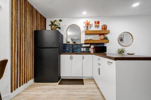 a kitchen with a black refrigerator and white cabinets at The Martin Frisco Stay & Play Hot tub, Pool & Firepit in Frisco