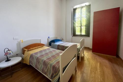 a bedroom with two beds and a table and a window at La CASA al CENTRO in LʼAquila
