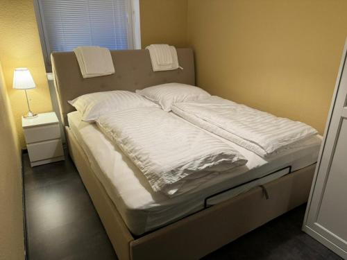 een bed met witte lakens en kussens erop bij Naturfreude Bad Harzburg in Bad Harzburg