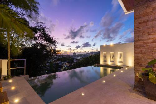 an infinity pool in a house with a sunset at Patong 180-degree stunning sea view modern 3-bedroom villa pool stunning sunset BBQ in Patong Beach