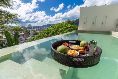 a basket of fruit on the edge of a swimming pool at Patong 180-degree stunning sea view modern 3-bedroom villa pool stunning sunset BBQ in Patong Beach