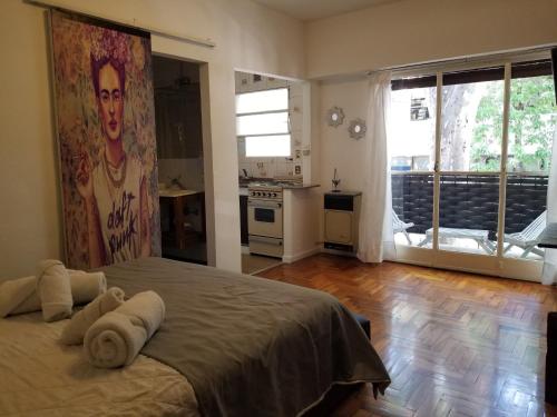 een slaapkamer met een groot bed met een schilderij aan de muur bij Bonpland Studio in Buenos Aires