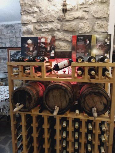 a bunch of wine bottles and barrels on a shelf at Guest House J.Prifti in Berat